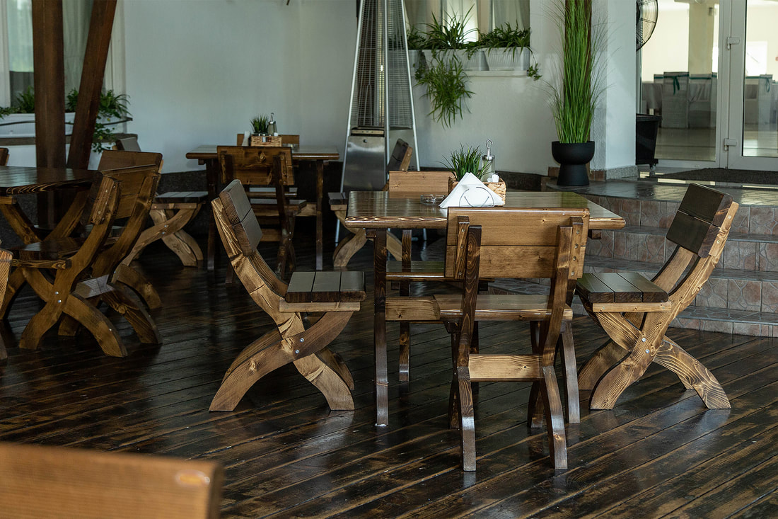 Terasa acoperită a restaurantului, cu mobilier masiv din lemn